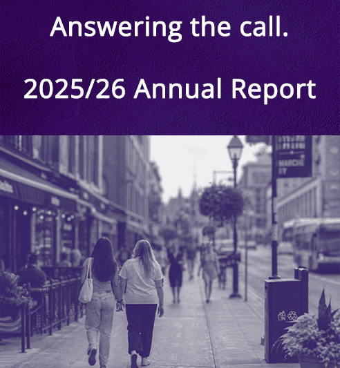 2025 & 2026 Annual report cover page showing "Answer the Call. 2025/26 Annual Report" on a purple background with white text. Below is an image of downtown and two women walking away from the camera casually, holding hands.