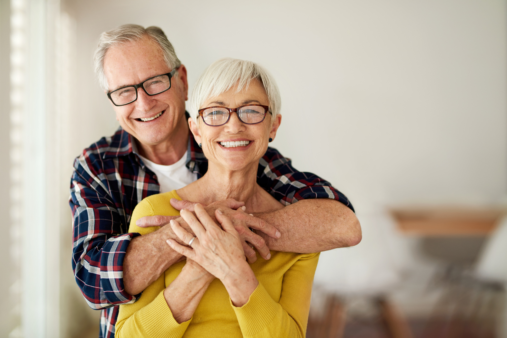 Cropped portrait of a senior man affectionately embracing his wife at home